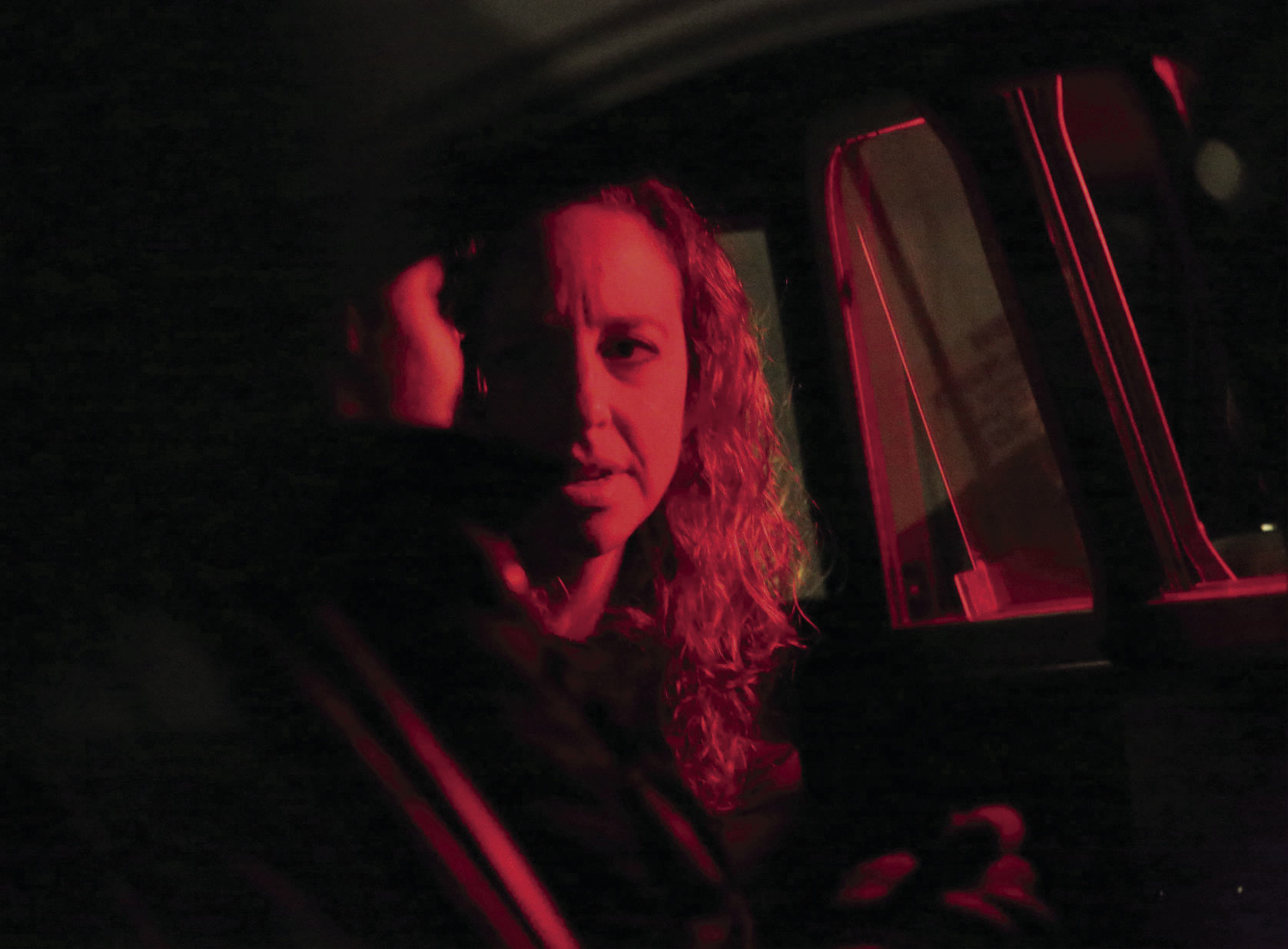 Sarah in red light talking to man